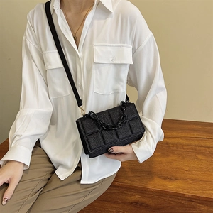 Grand sac bandoulière noir scintillant à matelassage et grosse chaîne tendance été