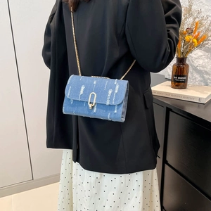 Light blue denim chain crossbody bag with vintage fringe texture and gold buckle