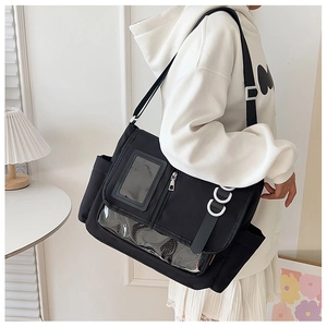 Détail du grand sac bandoulière noir avec fenêtre transparente porté par mannequin
