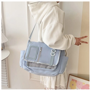 Détail du sac messager en nylon bleu clair avec poche transparente et compartiment filet