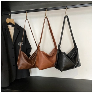 Détail de grands sacs cabas en cuir souple en marron foncé, caramel et noir classique