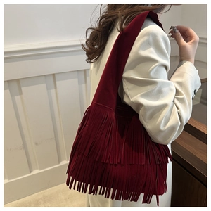 Detailweergave van bordeauxrode suède hobo tas met gelaagde franjes en kwastjes
