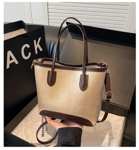 Detail of cream and brown patchwork bucket bag with twin handles and adjustable strap