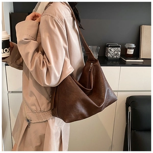 Detail of soft brown PU leather tote bag with natural texture and silver zipper closure