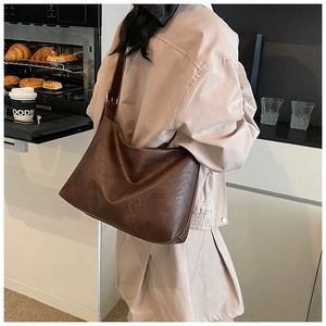 Détail de la texture cuir mat marron foncé et structure souple du sac cabas