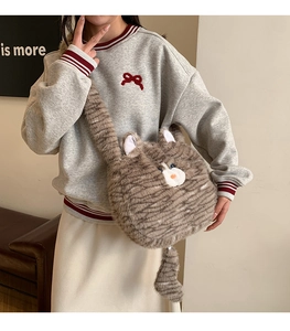 Detail of cute grey plush cat-shaped crossbody bag with soft long faux fur texture