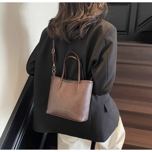 Detail of vintage brown bucket bag with textured leather and adjustable shoulder strap