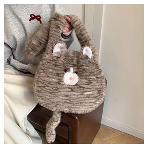 Detailed view of a cute cat-shaped plush tote bag with brown stripes and blue eyes