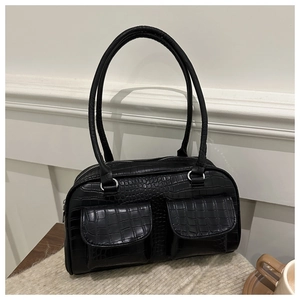Detail of black crocodile embossed shoulder bag with dual front pockets on soft fabric
