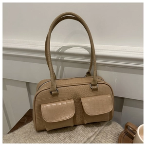 Detail of warm beige shoulder bag with crocodile pattern and dual front pockets