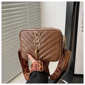 Detail of dark brown PU leather crossbody bag with V-quilting and golden S logo