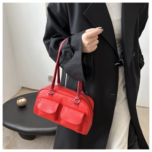 Close-up of red crocodile pattern shoulder bag with dual front pockets and top handle