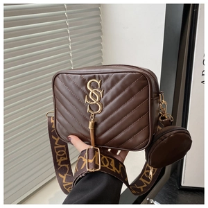 Detail of dark brown quilted camera bag with wide patterned strap and mini coin purse