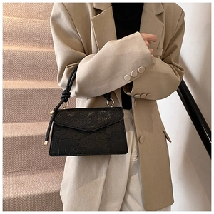 Detailed view of black PU leather handbag featuring elegant carp and lotus embossed patterns