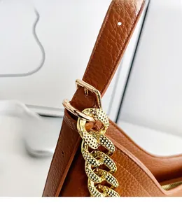 Dettaglio della borsa a spalla marrone in pelle litchi con catena dorata lucida