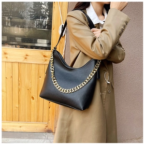 Dettaglio borsa hobo in pelle nera con catena dorata e trama a grana fine