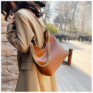 Dettaglio borsa hobo in pelle martellata marrone con catena dorata e tracolla larga