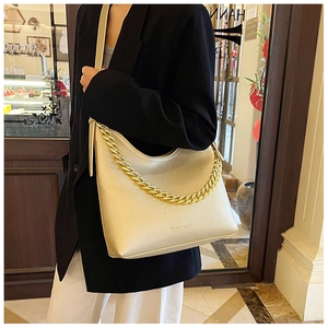 Dettaglio della borsa tote beige in pelle martellata con catena d'oro e logo Speed Mark