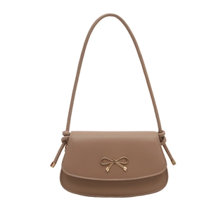 Minimalist tan crossbody bag with golden bow clasp and knot shoulder strap detail