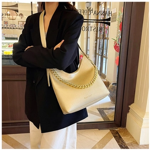 Dettaglio borsa hobo in pelle color oro champagne con catena dorata e logo Speed Mate