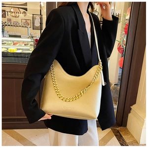 Dettaglio della borsa a spalla in pelle martellata color champagne con catena dorata