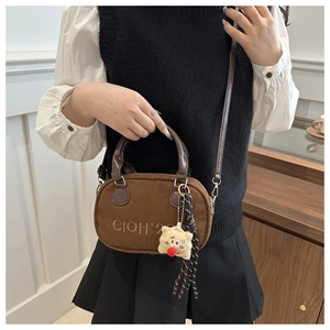 Detail of vintage brown bowling bag with embroidery, silk scarf and cookie plush charm
