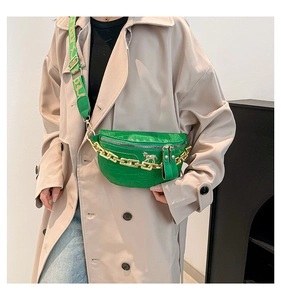 Détail du sac vert texture crocodile avec chaîne dorée et boucle de cheval en métal