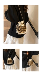 Detalle de bolso bandolera de leopardo con asa de perlas y cadena metálica fina