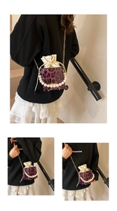 Detalle del mini bolso de leopardo morado con asa de perlas y cadena dorada
