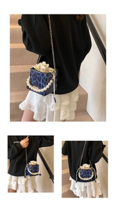 Detalle del bolso rígido de leopardo azul con asa de perlas y cadena dorada