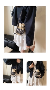 Detalle de mini bolso de leopardo con asa de perlas y correa de cadena dorada