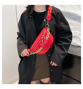 Détail du sac de poitrine rouge texture crocodile avec chaîne dorée et sangle