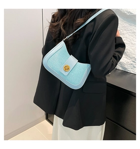 Close-up of light blue woven leather shoulder bag featuring a gold twist lock buckle detail