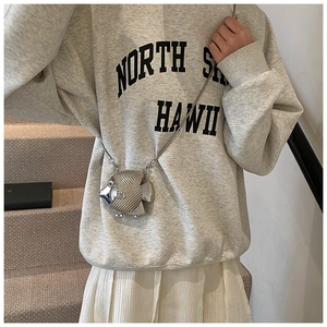 Close-up of a silver fish-shaped mini bag with scale textures on a metal chain strap