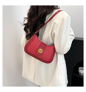 Detail of red tweed hobo bag with gold twist lock on a white oversized blazer