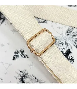Detail of adjustable off-white woven strap with polished gold metal buckle on a backpack