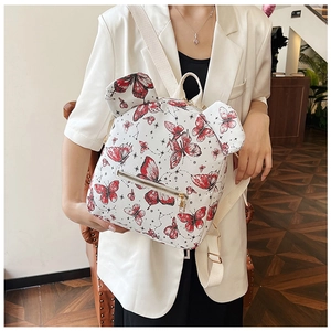 Detail of white commuter backpack with red butterfly print and decorative round ears