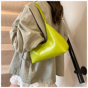 Detail of lime green half-moon hobo bag with MISSING embossed text on smooth leather