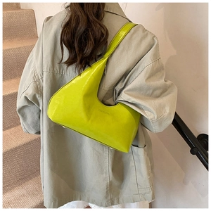 Close-up of bright green crescent underarm bag with embossed logo on wide strap leather