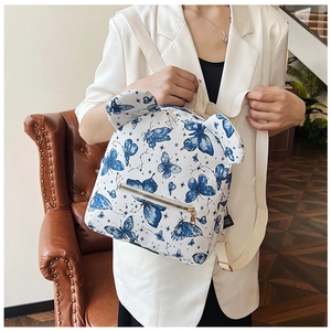 Close-up of white backpack featuring blue butterfly prints and 3D decorative ears