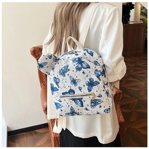 Detailed back view of a white mini backpack with blue butterfly prints and cute ears