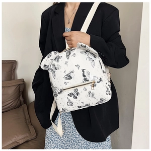 Detail of white backpack with black butterfly prints and cute ear decorations