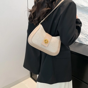Beige crescent shoulder bag with golden round buckle and subtle glitter fabric finish