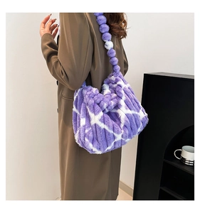 Dettaglio borsa a tracolla in ecopelliccia a righe viola e bianche con cinturino pom-pom