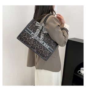Détail du sac cabas léopard avec ruban élégant porté par un mannequin femme