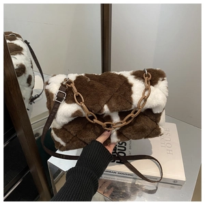 Dettaglio borsa a tracolla in peluche stampa mucca con motivo trapuntato e catena