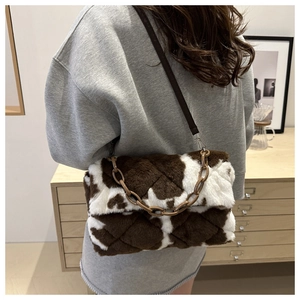 Détail du sac à bandoulière en peluche motif vache avec matelassage et chaîne acrylique
