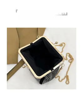 Open view of black rhinestone clutch bag showing interior storage and gold chain strap