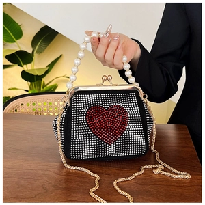 Detailed view of luxury evening bag with pearl handle and rhinestone heart pattern