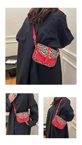 Dettaglio borsa a tracolla in pelle rossa con stampa leopardata e fibbia dorata vintage